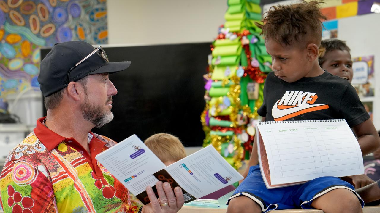 Fregon Anangu School teacher assistant Paul Tidswell helps with reading lessons. Picture: Dean Martin