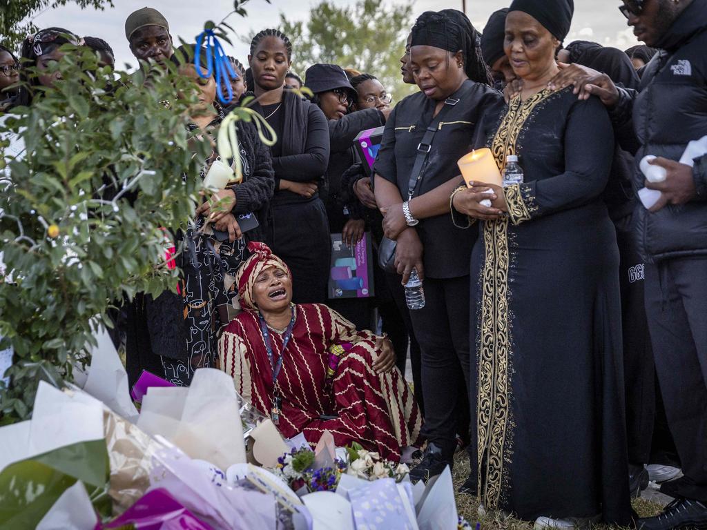 Mourners are brought to the ground in grief. Picture: Jake Nowakowski