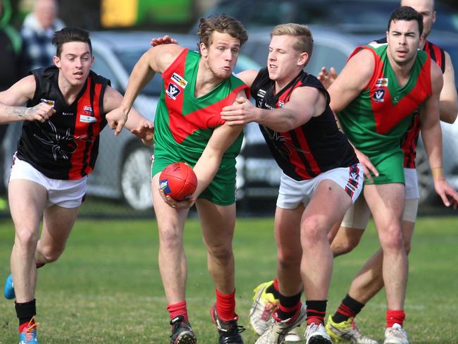 Tooradin’s Andrew Proctor dishes out a handball. Picture: Hamish Blair