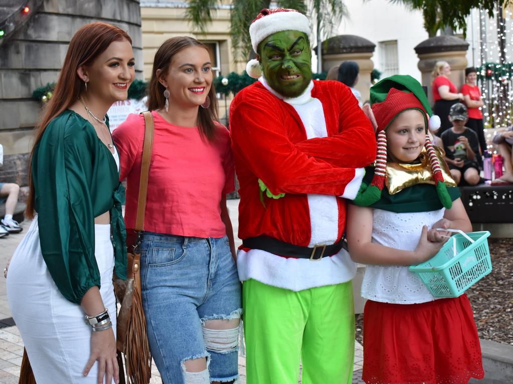 Katrina Todd and Amber Patteson with the Grinch and his offsider at the CBD Christmas Fair in Rockhampton on December 3, 2022.