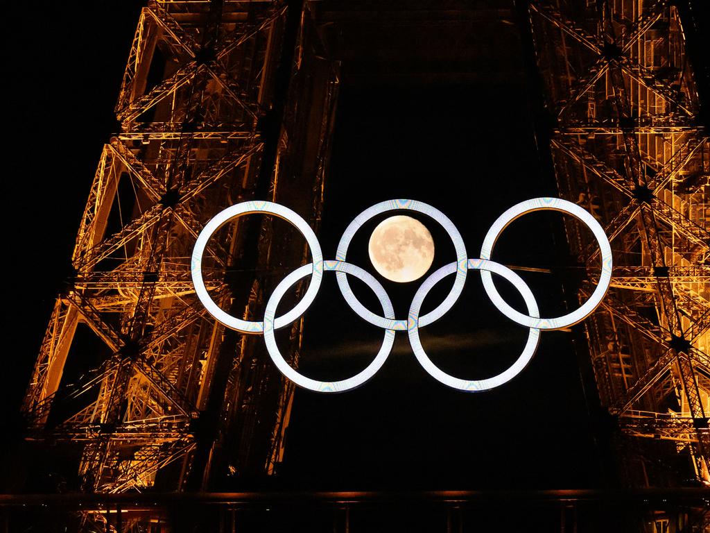 The moon rises behind the Olympic rings displayed on the Eiffel Tower in Paris on July 22, 2024, ahead of the Paris 2024 Olympic Games. Picture: AFP