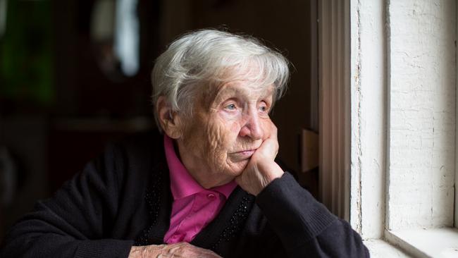 An elderly woman sadly looking out the window. Picture: iStock.