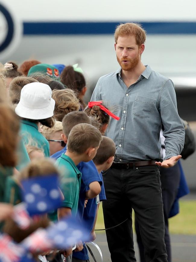 Prince Harry chats to waiting children. Picture: Getty