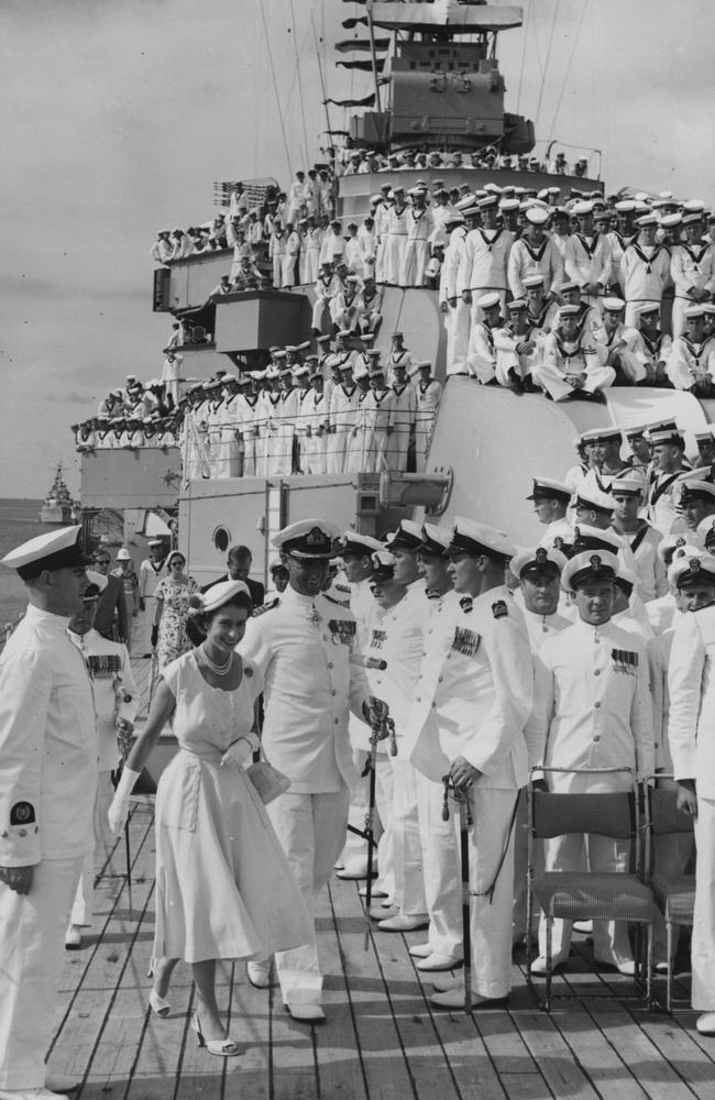 1954: Queen Elizabeth II and Prince Philip, Duke of Edinburgh, on board HMAS Australia at sea off Townsville, Queensland, during a royal tour of Australia. Captain A W R McNicoll, commander of the ship, is on the left. Picture: Central Press/Getty Images