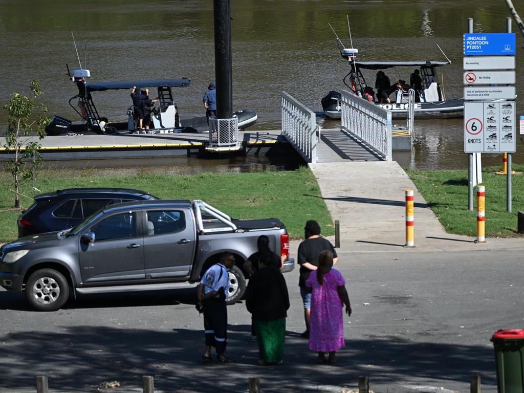 Police boats in the river near where a man fell in. Several people, including those believed to be relatives of the missing man, watch on. Picture: Lyndon Mechielsen