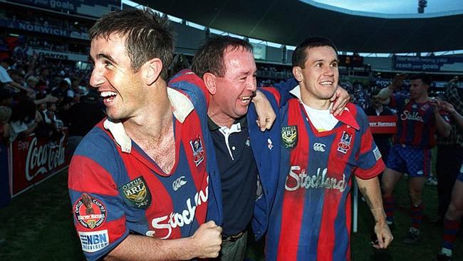 Matthew Johns (right) celebrates the 1997 grand final with brother Andrew (left) and their father.Photo: News Corp