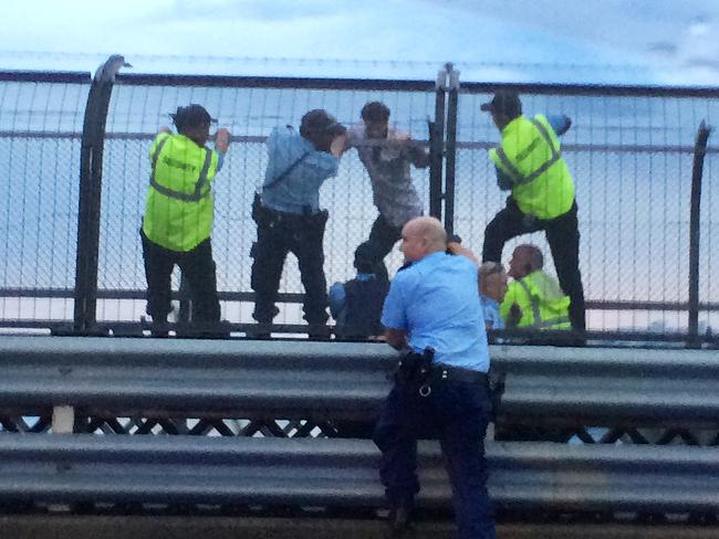 Constable Arun Trevitt (second from left) holds on to Dan Price as he attempts to take his own life on the Sydney Harbour Bridge on December 4, 2014. Picture: Jeff Herbert