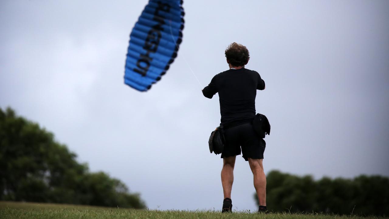 A man with his kite in strong winds at Sydney Park in Alexandria. Picture: Christian Gilles