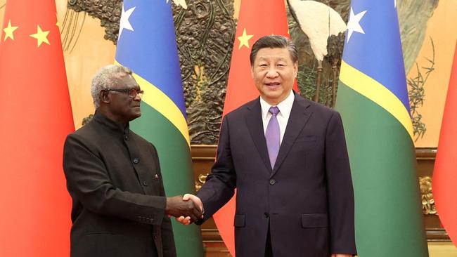 Chinese President Xi Jinping and Solomon Islands Prime Minister Manasseh Sogavare shake hands at the Great Hall of the People in Beijing.