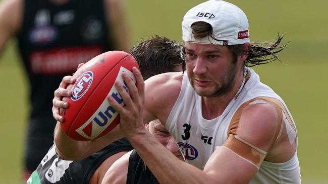 Rupert Wills crashes through a tackle at Collingwood training.