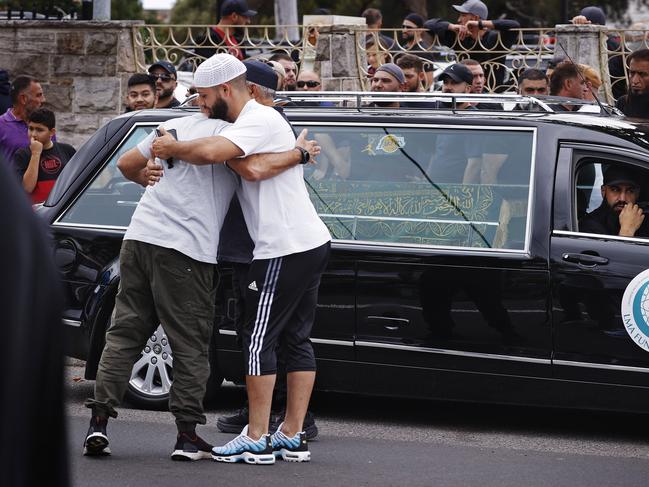 Two men comfort one another outside the mosque. Picture: Sam Ruttyn