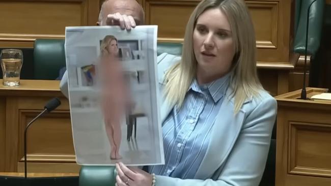 Laura McClure holds up doctored nude image of herself. Picture: YouTube / ACT New Zealand