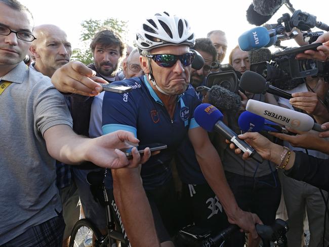 Lance Armstrong is surrounded by journalists before setting off on the stage.