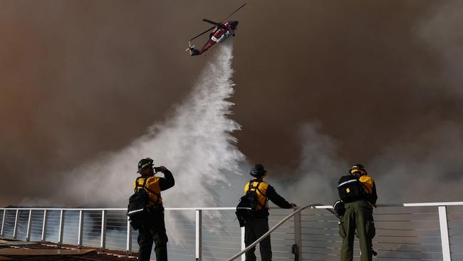 A firefighting helicopter drops water on the Palisades Fire. Picture: AFP