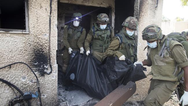 Israeli soldiers remove the body of civilian killed days earlier in an attack by Palestinian militants on the Kfar Aza kibbutz near the border with Gaza. Picture: Amir Levy/Getty Images