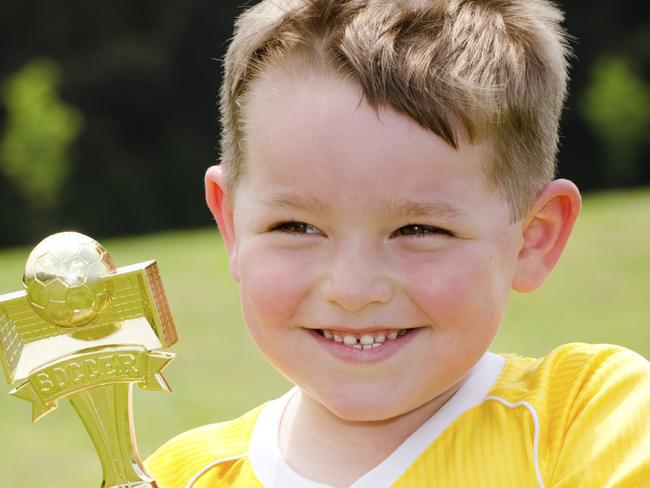 RendezView. Trophy. Award. Generic. Young soccer player in uniform with his new trophy.