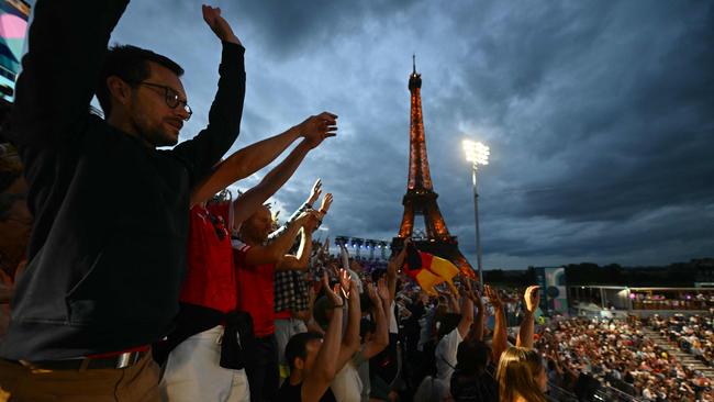 Spectators cheer in the men's quarterfinal beach volleyball match between Spain and Norway. (Photo by CARL DE SOUZA / AFP)