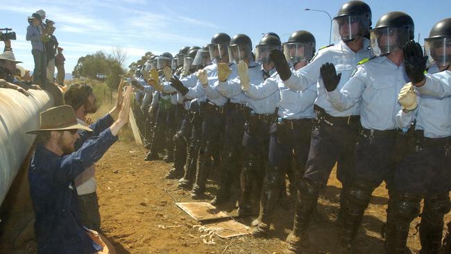 Protesters kneel in front of Star Group police outside the Baxter Immigration Detention Centre in 2005. Picture: Mark Brake