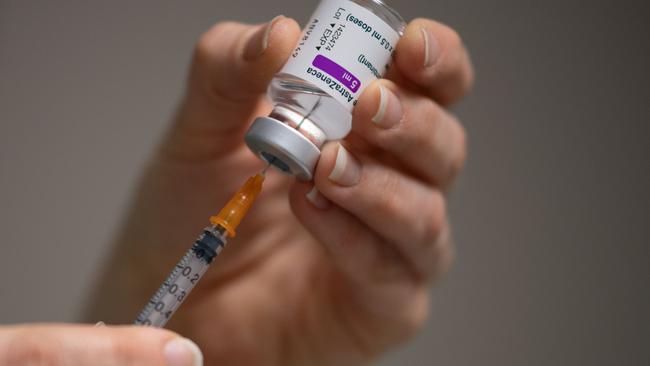 A pharmacist prepares a dose of the AstraZeneca vaccine .