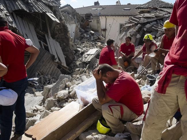 Rescuers pause in Amatrice, as they desperately search for those buried under the rubble. Picture: AP/Emilio Fraile
