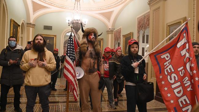 Trump supporters, including member of the QAnon conspiracy group Jake Angeli, aka Yellowstone Wolf (C), enter the US Capitol in Washington, DC on January 6, 2021.