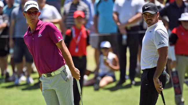 Lucas Herbert and Jason Day watch a putt during the final round of the Australian Open.