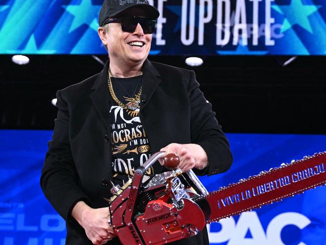 Elon Musk holds a chainsaw reading "Long live freedom, damn it" during the annual Conservative Political Action Conference (CPAC) at the Gaylord National Resort & Convention Center at National Harbor in Oxon Hill, Maryland, on February 20, 2025. (Photo by SAUL LOEB / AFP)