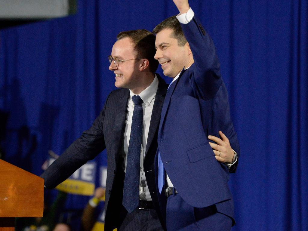 Pete Buttigieg (right) and his husband Chasten Buttigieg wave to supporters at the conclusion of his primary night rally at Nashua Community College. Picture: Joseph Prezioso/AFP