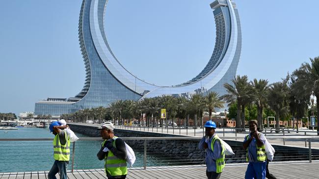 Construction workers walk along the marina near the Katara Towers in the Qatari coastal city of Lusail ahead of the 2022 World Cup. Picture: AFP