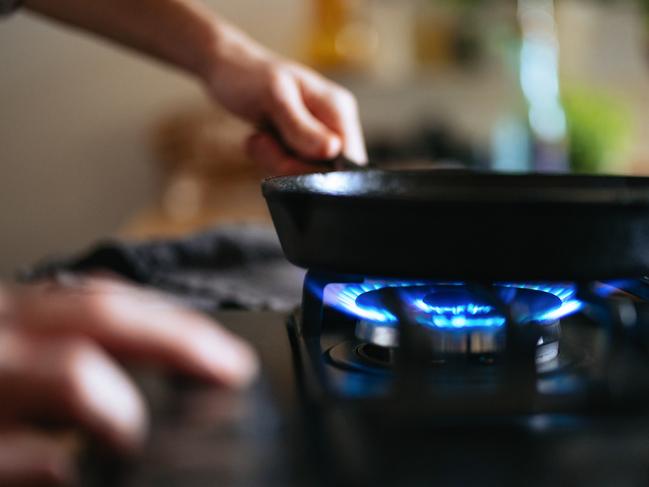 An anonymous man preparing lunch in a pan in the kitchen.