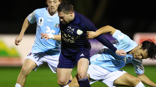 Chris Lucas holds off a Brisbane City defender in the Australia Cup.