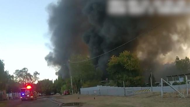 Quick thinking: Bodycam footage shows a Mount Isa police officer rescuing two dogs from a property near the raging industrial fire on Duchess Road. Source: QPS