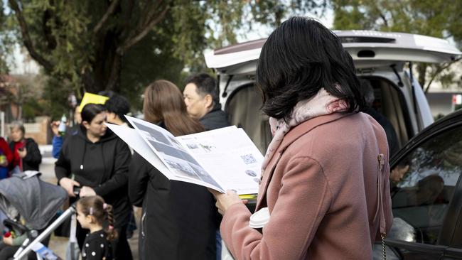 Prospective buyers gather outside a Sydney property ahead of an auction.