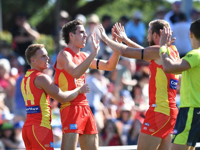 Ben King of the Suns (centre) celebrates scoring a goal with teammates during the Round 13 AFL match between the Gold Coast Suns and the St Kilda Saints at Riverway Stadium in Townsville, Saturday, June 15, 2019. (AAP Image/Dan Peled)