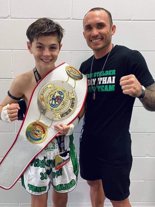 Jayden Carroll with his coach Brodie Stalder after being crowned the 12 year old Muay Thai Siam Australian champion. Picture: Contributed