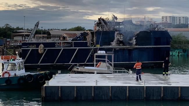 Emergency services personnel remained on the scene at Hornibrook’s Wharf hosing down and mopping up aboard the MV Guru Wednesday morning. Picture: NT News