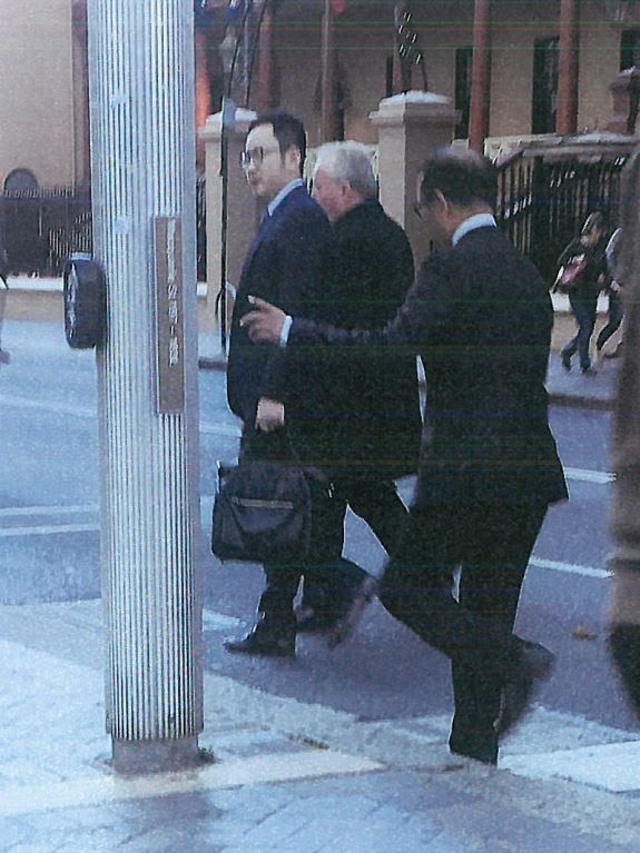 A man believed to be SU Baiyuan (far right) and Tim Lakos (centre) on Macquarie Street in 2017.