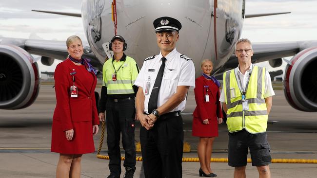 Virgin staff Chelsea Dodd, Phil Vlieg, Anthony Saville, Kelby Buchanan and Peter Armstrong posing in front of Long Beach, 737-800 at the Brisbane Domestic Airport.