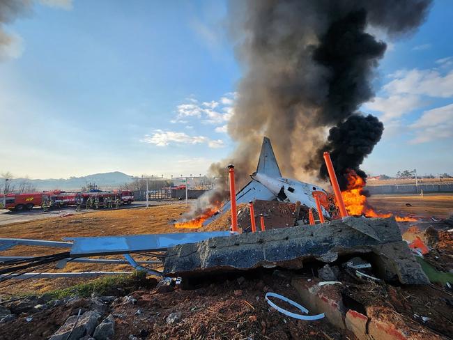 Fire and smoke rise from the tail section of a Jeju Air Boeing 737-800 series aircraft after the plane crashed and burst into flames at Muan International Airport, South Korea. Picture: AFP