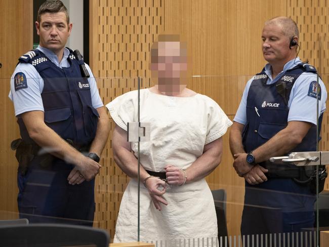 Brenton Tarrant making a sign to the camera during his appearance, for murder, in the Christchurch District Court. Picture: New Zealand Herald photograph by Mark Mitchell