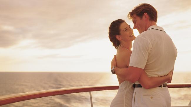 Generic pic of a couple embracing while standing on the deck of a Pride of Aloha cruise ship out at sea.