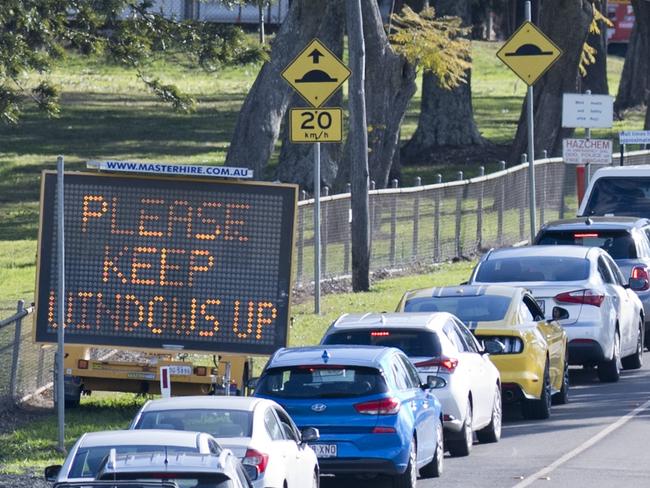 Cars line up while drivers wait for testing at Baillie Henderson COVID 19 fever clinic. Thursday, 30th Jul, 2020.