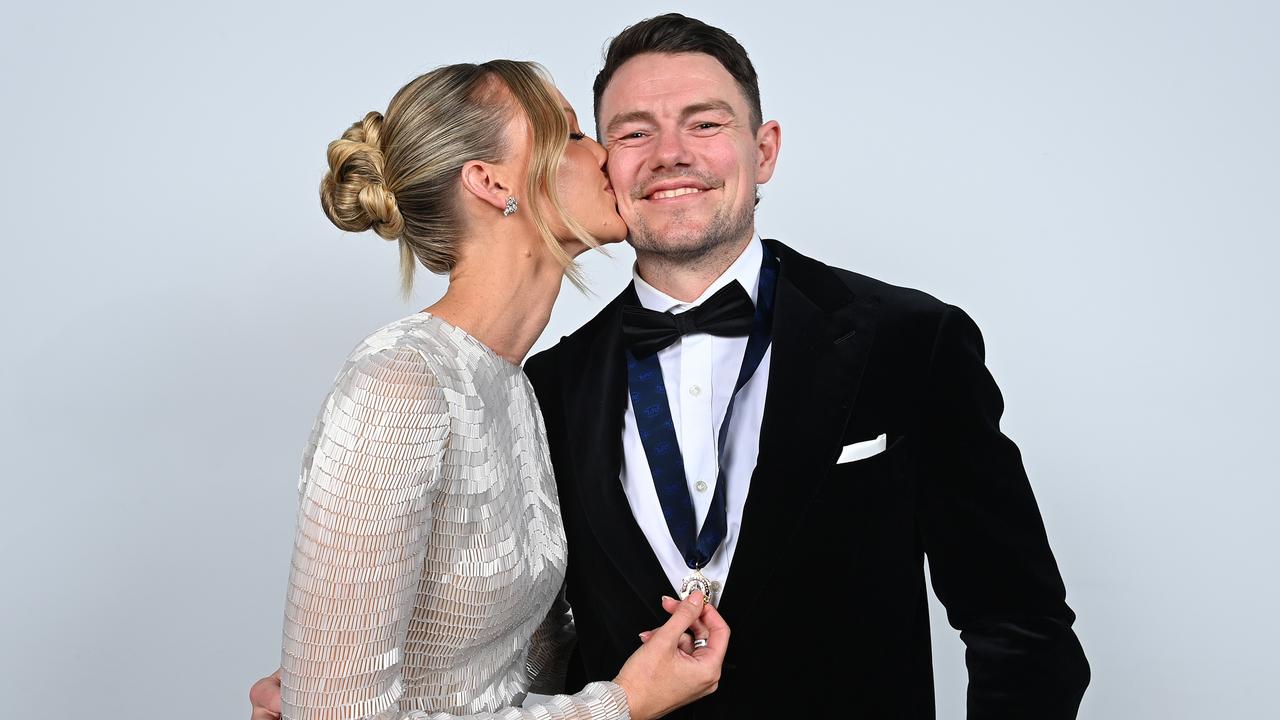 Lion Lachie Neale and wife Julie pose for portraits with the 2023 Brownlow Medal. Picture: Albert Perez