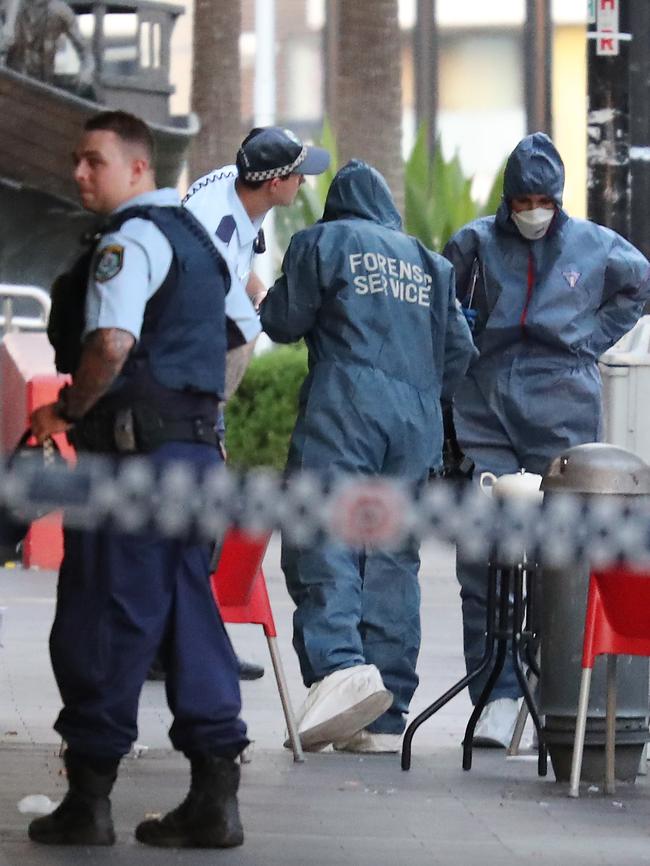 Forensic officer search bins following the shooting. Picture: David Swift.