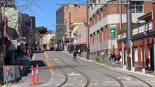 Pedestrians interact with the Sydney light rail