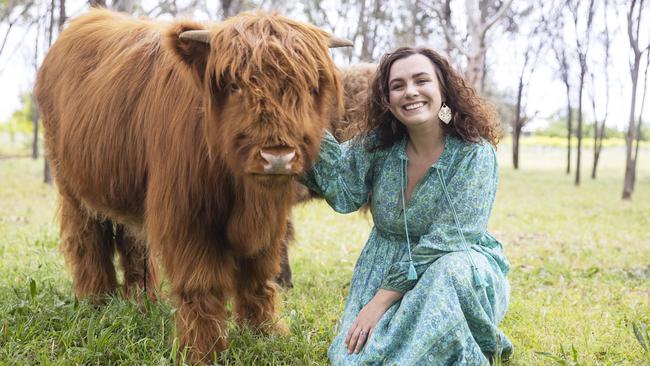 Chloe Grayling from the Fleurieu Peninsula with one of her highland cows. Picture Simon Cross