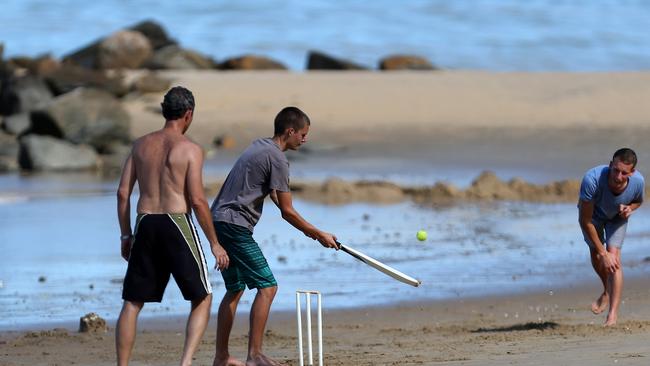 Paul Kappal, Sebastian Kappel and Michas Richter play cricket at Ellis beach near Cairns.