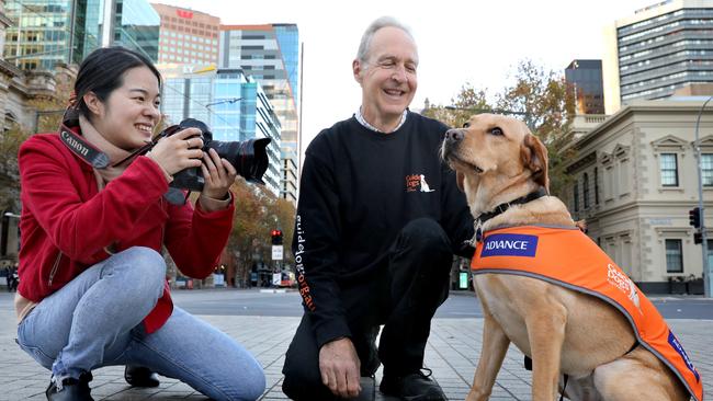 Volunteer photographer Fumika Takagi with Guide Dogs SA/NT volunteer Howard Duchene and Guide Dog JoJo. Picture: Dean Martin