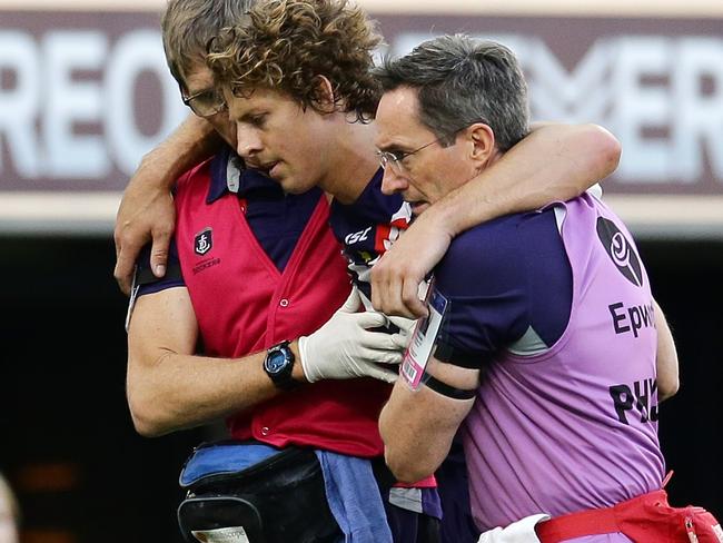 Fremantle star Nat Fyfe is helped from the field. Picture: Will Russell/AFL Media/Getty Images