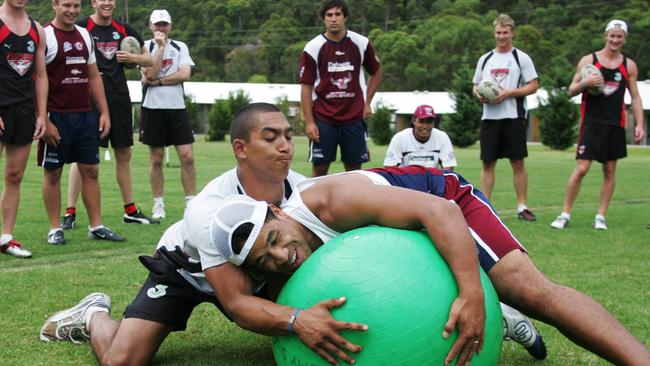 AFL Bomber Damien Cupido and Sea Eagle John Hopoate (cap) during a wrestling drill.